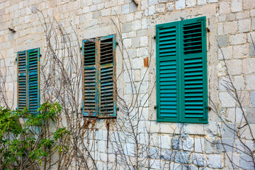Fototapeta na wymiar Authentic, brick wall with beautiful, old, wooden shutters, window and dry ivy, minimal style, bright colors, background
