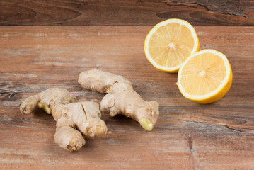 Closeup image of ingredients for natural cold or flu remedy includes ginger and lemon on a brown...