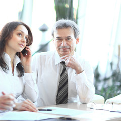 business colleagues analyzing financial statistics sitting at a Desk