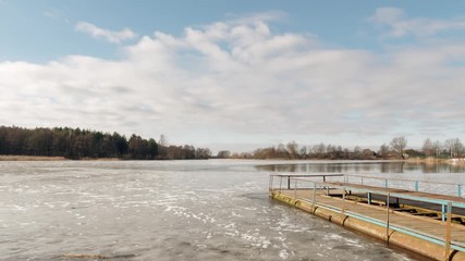 the beginning of spring. jetty on the lake in the ice.
