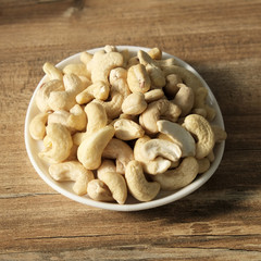 Cashew nuts on a wooden background in a plate. Beautiful nuts on the table