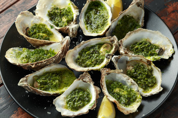 Grilled oysters with Parsley and garlic butter served with parmesan and lemon wedges