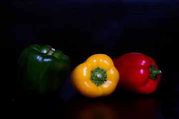 sweet pepper of different colours on black background