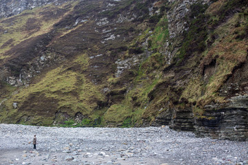 The girl on the rocky beach near cliff , Achill Ireland 