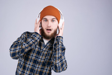 Amazed and surpirsed handsome bearded man enjoy listening music with earphones. Dancing rapper. Man in funny hat enjoying his favorite track. New music service subscriber
