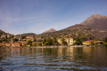 Fototapeta na wymiar Italy, Menaggio, Lake Como, a large body of water with a mountain in the background