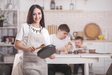 Young housewife on kitchen background. Woman at home kitchen. Female cooking with copy space.