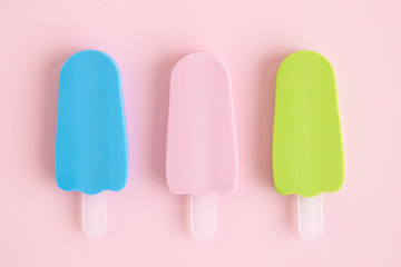 Multicolored ice cream on stick sweet food abstract on rose.