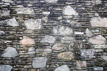 Stone rock wall with beautiful pattern for background.  Texture and design in this stonework aged structure.