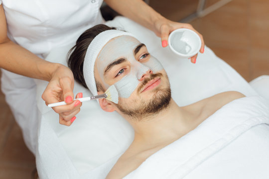 Unshaven man having cosmetic mask care in spa salon, side, top view - Image