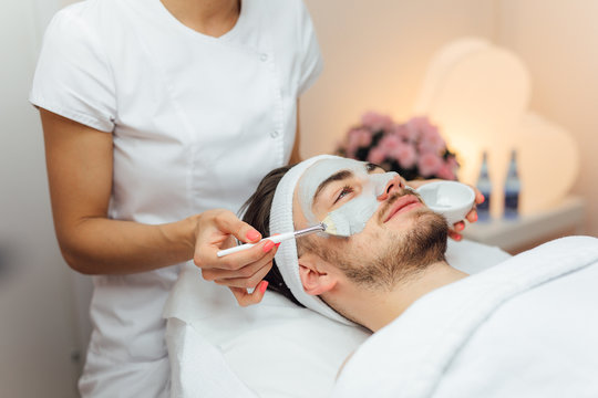 Unshaven man having cosmetic mask care in spa salon, side, top view - Image