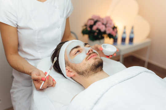 Unshaven man having cosmetic mask care in spa salon, side, top view - Image