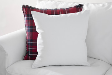 Mockup of white square cushion with red plaid square cushion on a white sofa.