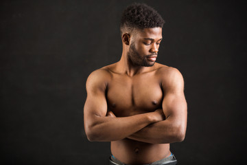 handsome african man with muscles on black background