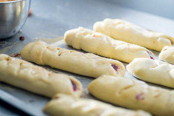 raw bread rolls on a baking tray