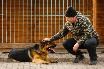 The man affects the dog, obedient and loving dog, captive dogs pull their heads through the bars,...