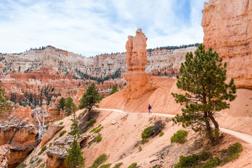 Fototapeta na wymiar Hiker woman in Bryce Canyon hiking looking and enjoying view during her hike wearing hikers backpack. Bryce Canyon National Park landscape, Utah, United States.