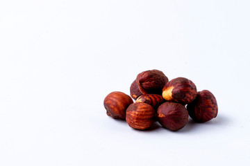 Heap of hazelnuts on white background.