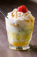 Ice cream with topping and berries in a glass