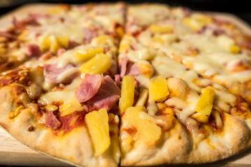 Close up view of a ham and pineapple Hawaiian pizza
