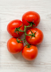 Fresh raw tomatoes on white wooden surface, top view. From above, flat lay, overhead. Close-up.