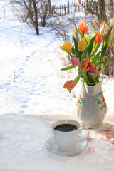 A cup of coffee and flowers on a light background, wishes of good morning and good day, a cozy home