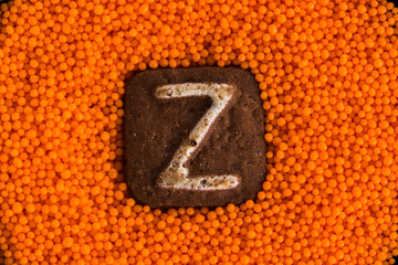 cookies with letters on the background of orange sweet balls