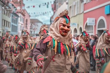 Group of friendly carnival figures run in a row. Carnival in southern Germany - Black Forest.