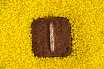 letters of the English alphabet on the background of yellow sweet balls