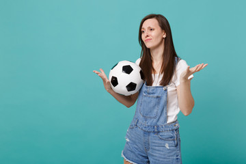 Disconcerted displeased young woman football fan support favorite team with soccer ball spreading...