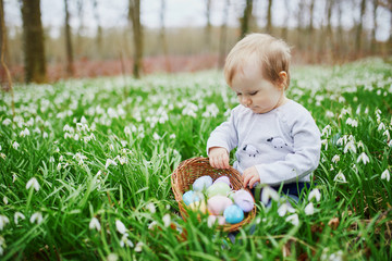 Cute little one year old girl playing egg hunt on Easter