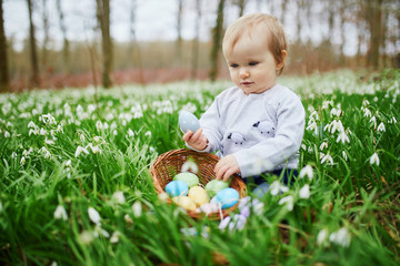 Cute little one year old girl playing egg hunt on Easter