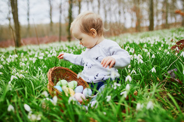 Cute little one year old girl playing egg hunt on Easter