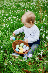 Cute little one year old girl playing egg hunt on Easter