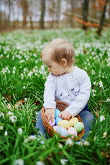 Cute little one year old girl playing egg hunt on Easter