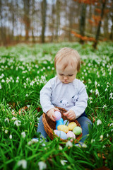 Cute little one year old girl playing egg hunt on Easter