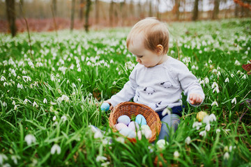 Cute little one year old girl playing egg hunt on Easter