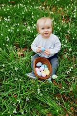 Cute little one year old girl playing egg hunt on Easter