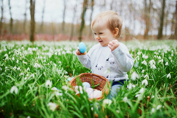 Cute little one year old girl playing egg hunt on Easter
