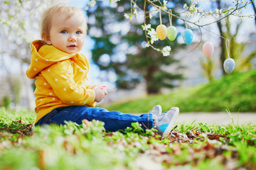 Cute little one year old girl playing egg hunt on Easter