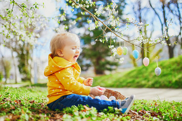 Cute little one year old girl playing egg hunt on Easter