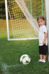 little happy girl on football field