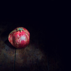Vintage still life with pot and pomegranate on old table