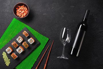 Set of sushi and maki with a bottle of wine on stone table. Top view with copy space