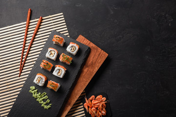 Set of sushi and maki with a bottle of wine on stone table. Top view with copy space