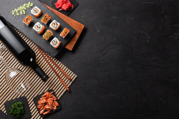 Set of sushi and maki with a bottle of wine on stone table. Top view with copy space