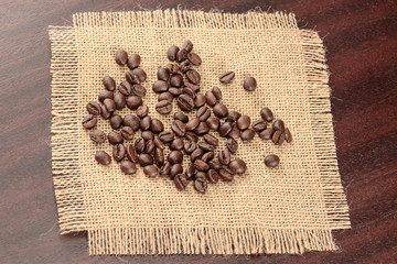 Vintage coffee background. Roasted coffee beans on jute burlap napkin.