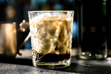 White Russian cocktail. The bartender prepares it in a glass of ice.