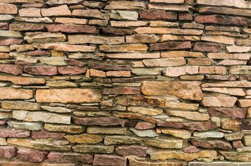 A wall of small stones. Texture of yellow stones. Stony background.