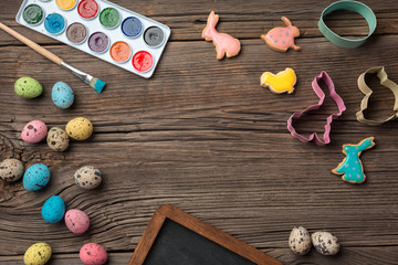 Colorful easter eggs and brushes on wooden table. Top view with copy space